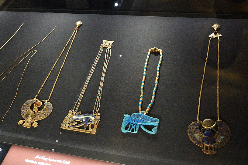 61 MAK_7176.jpg - Alcune sue collane con amuleti raffiguranti lo scarabeo alato e l'Occhio di Horus, in oro, vetro di silice e pietre semipreziose intarsiate